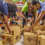 Team of volunteers sorting and packing food donations for a local charity initiative.