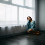 woman sitting on floor near window