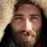 man covered by beige fur textile